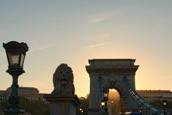 Widok na sylwetkę Chain Bridge podczas jesiennego zachodu słońca. Piękna rzeźba Lwa i starożytnej latarni. Romantyczna i spokojna scena. Panoramiczne dramatyczne niebo zachodu słońca. Budapeszt, Węgry — Zdjęcie stockowe