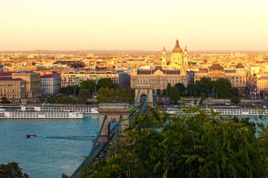 Budapeşte manzaralı sonbahar manzarası. Tuna Nehri üzerindeki Antik Zincir Köprüsü. Şehirde günbatımı. Nehrin seti boyunca ortaçağ binaları. Seyahat ve turizm konsepti. Budapeşte, Macaristan