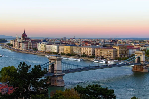 Budapest légi tájképe. Festői kilátás nyílik a Lánchídra a Duna felett és a Magyar Parlament épületére a háttérben. Szcenírozott őszi naplemente színek. Budapest, Magyarország — Stock Fotó