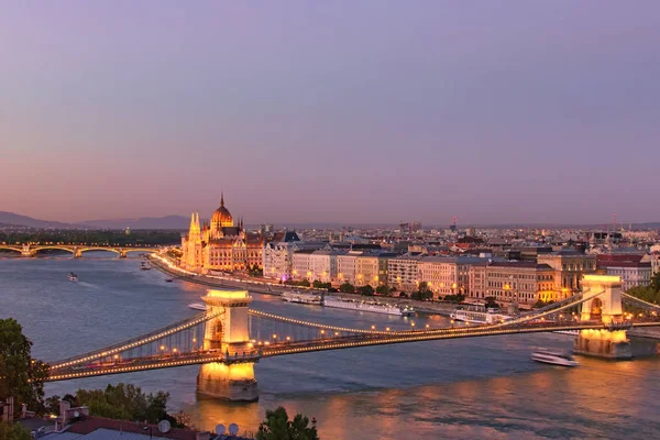 Zdumiewający widok na centrum Budapesztu. Krajobraz świateł nocnych z oświetlonym mostem łańcuchowym i budynkiem parlamentu węgierskiego. Zdjęcie krajobrazowe w złotej godzinie. Budapeszt, Węgry — Zdjęcie stockowe