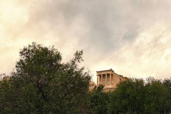 Beautiful landscape photo of Temple of Athena Nike. Dedicated to the goddess Athena Nike. Built around 420 BC. Tree Leaves Border. Natural Frame. Stormy sky and gloomy clouds. Athens Greece — Stock Photo, Image