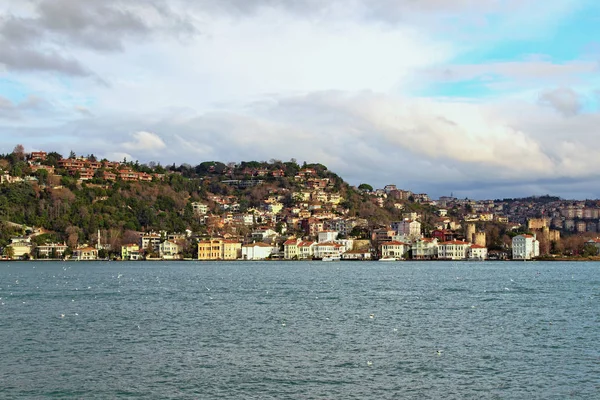 博斯普鲁斯海峡（博斯普鲁斯海峡或伊斯坦布尔海峡）附近山丘上的住宅建筑风景如画。 城市上空乌云密布. 土耳其伊斯坦布尔冬日 — 图库照片