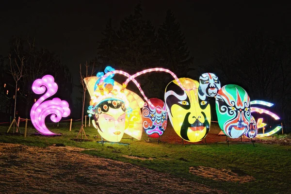 Kiev, Ucrania-25 de enero de 2020: Hermosa instalación de máscaras de carnaval gigantes. Figuras iluminadas por muchas linternas durante el Festival de las linternas chinas — Foto de Stock