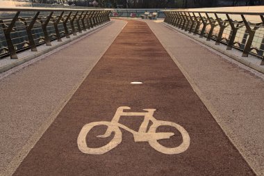 New Pedestrian Köprüsü 'nün ortasında kırmızı renkli bisiklet yolu üzerinde beyaz bir bisiklet tabelası. Geniş açılı manzara manzarası. Kyiv, Ukrayna.