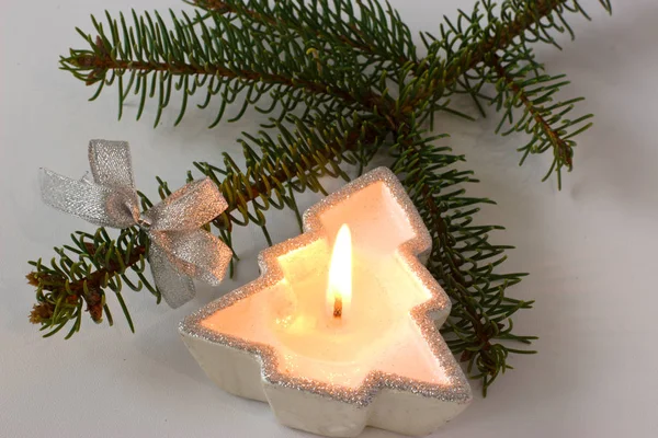 Fur-tree branch and candle on a white background. — Stock Photo, Image