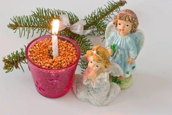 Fur-tree branch and candle on a white background. Figures of ang — Stock Photo, Image