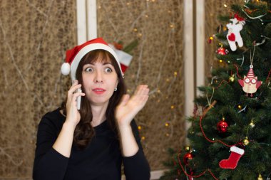 Noel Baba da telefonda konuşurken şapkalı kız. 