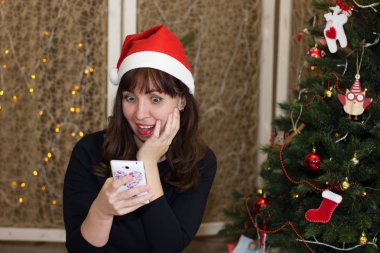 Noel Baba da telefonda konuşurken şapkalı kız. 