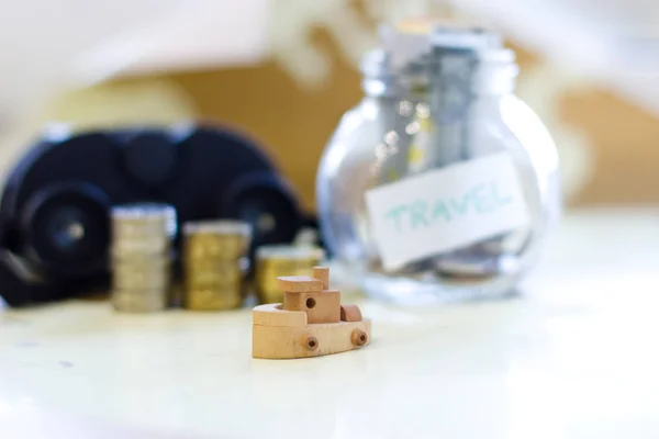 Travel budget - vacation money savings in a glass jar on world m