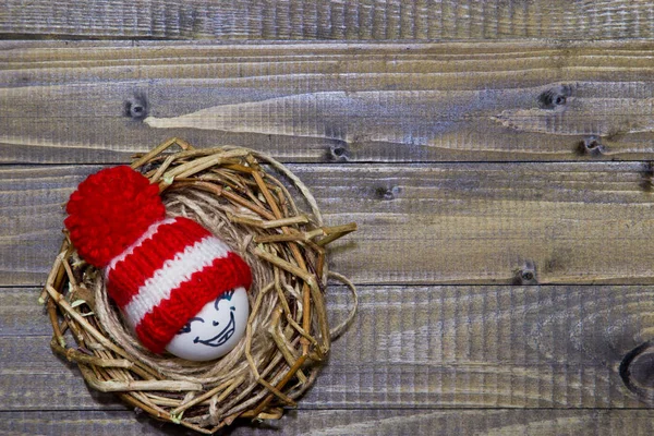 Œufs de Pâques dans le nid. Émoticônes en bonnets tricotés avec pompons — Photo