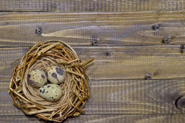 Πασχαλινά αυγά στη φωλιά. Ξύλινο υπόβαθρο. — Φωτογραφία Αρχείου