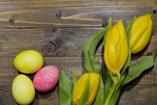 Ostereier bemalt. ein Strauß gelber Tulpen. — Stockfoto
