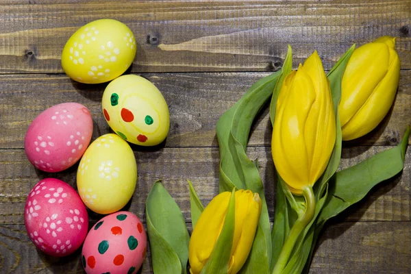 Painted Easter eggs . A bouquet of yellow tulips. — Stock Photo, Image