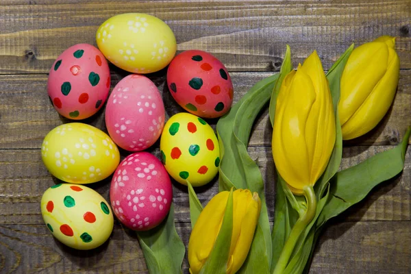 Painted Easter eggs . A bouquet of yellow tulips. — Stock Photo, Image