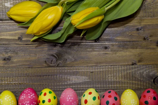 Ostereier bemalt. ein Strauß gelber Tulpen. — Stockfoto