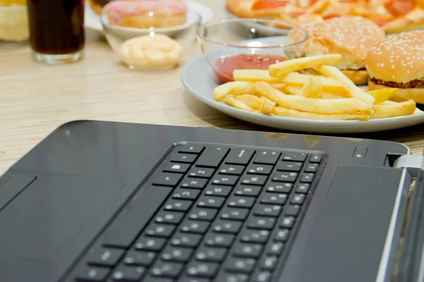 Work at the computer and fast food. unhealthy food: Burger, sauc — Stock Photo, Image
