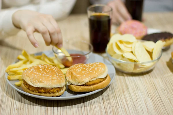 Ongezonde concept. Een paar vrienden zitten aan de tafel — Stockfoto