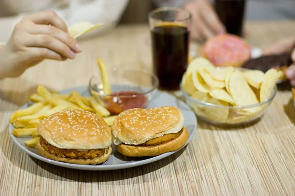 Ongezonde concept. Een paar vrienden zitten aan de tafel — Stockfoto