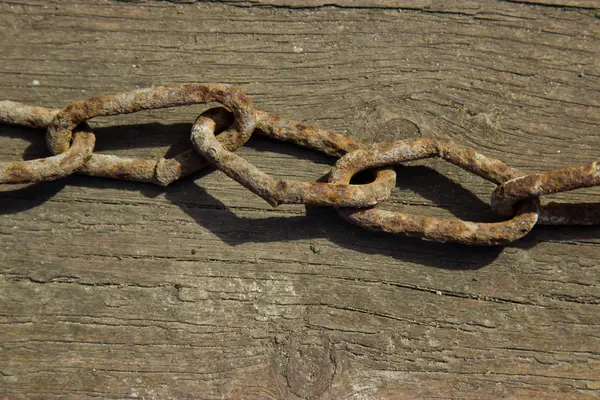The old rusty chain. Wooden background. — Stock Photo, Image
