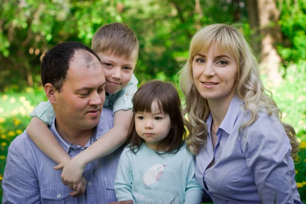 Ritratto di famiglia in un parco primaverile . — Foto Stock