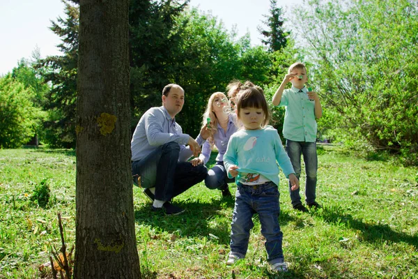 En familj på fyra personer får göra såpbubblor. — Stockfoto