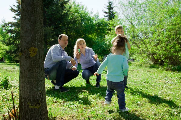 Een gezin van vier personen mogen zeepbellen. — Stockfoto