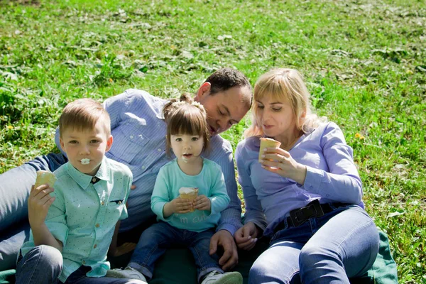 Una famiglia di quattro persone mangia gelato all'aperto . — Foto Stock