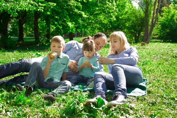 Una familia de cuatro comen helado al aire libre . — Foto de Stock