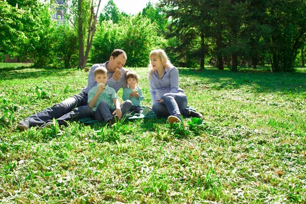 Una famiglia di quattro persone mangia gelato all'aperto . — Foto Stock