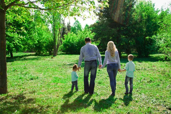 Parkta dört Yürüyen bir aile. 