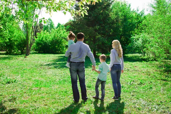 Une famille de quatre promenades dans le parc . — Photo