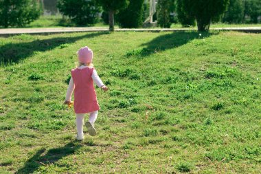 Küçük kız parkta oynuyor. 