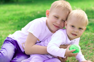 Kardeş kardeşi parkta sarılmak. Parlak güneşli s