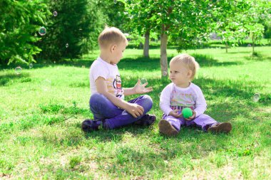 İki kardeş bir köpek ve sabun köpüğü parkta oynamak. 