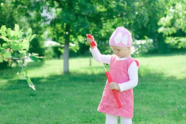 Une petite fille apprend à souffler des bulles . — Photo