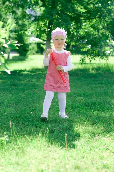 Uma menina está aprendendo a soprar bolhas . — Fotografia de Stock