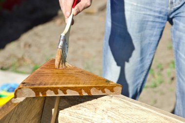 Adam inşaat bir fırça ile vernik ağacı kapak. 