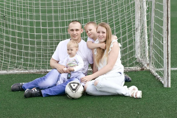 Una famiglia di quattro persone su un campo da football. Luminosa giornata estiva soleggiata . — Foto Stock