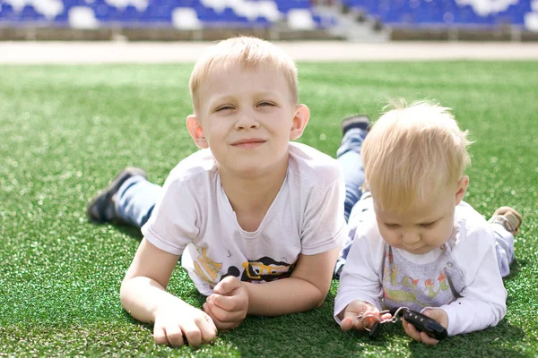 Deux frères s'allongent sur le terrain de football . — Photo