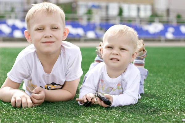 Deux frères s'allongent sur le terrain de football . — Photo