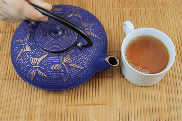 Blaue chinesische gusseiserne Teekanne. der Prozess des Teeaufbrühens. — Stockfoto