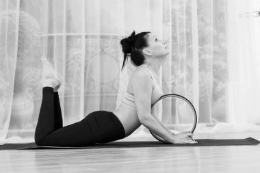 Orta yaşlı bir kadın ile bir tekerlek yoga yapar.