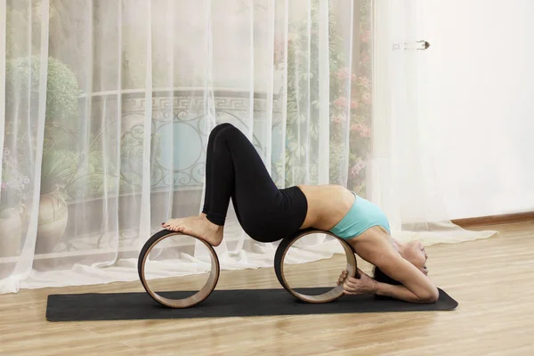 Una mujer de mediana edad hace yoga con una rueda . — Foto de Stock