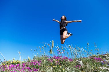 Güzel, genç bir kız bayırın yamacında zıplıyor. Geç kalmışsın.
