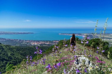 Güzel, genç bir kız bayırın yamacında zıplıyor. Geç kalmışsın.