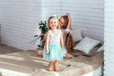 Küçük kız, güneşli gün ışığı altında annesini tebrik ediyor..