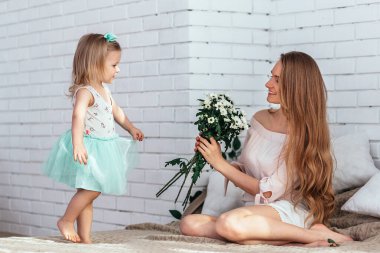 Küçük kız, güneşli gün ışığı altında annesini tebrik ediyor..