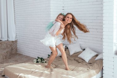 Anne ve kızı birlikte eğleniyor. Anne kızını sırtında taşıyor..