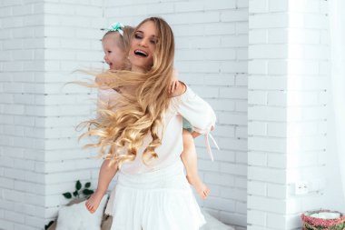 Anne ve kızı birlikte eğleniyor. Anne kızını sırtında taşıyor..