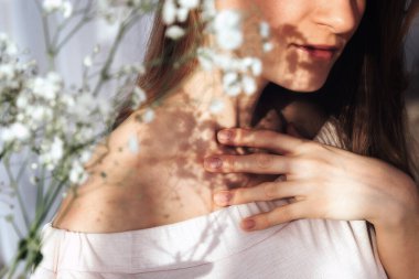 Yüzünde çiçeklerin gölgesi olan güzel bir portre. Sert güneş ışığı.